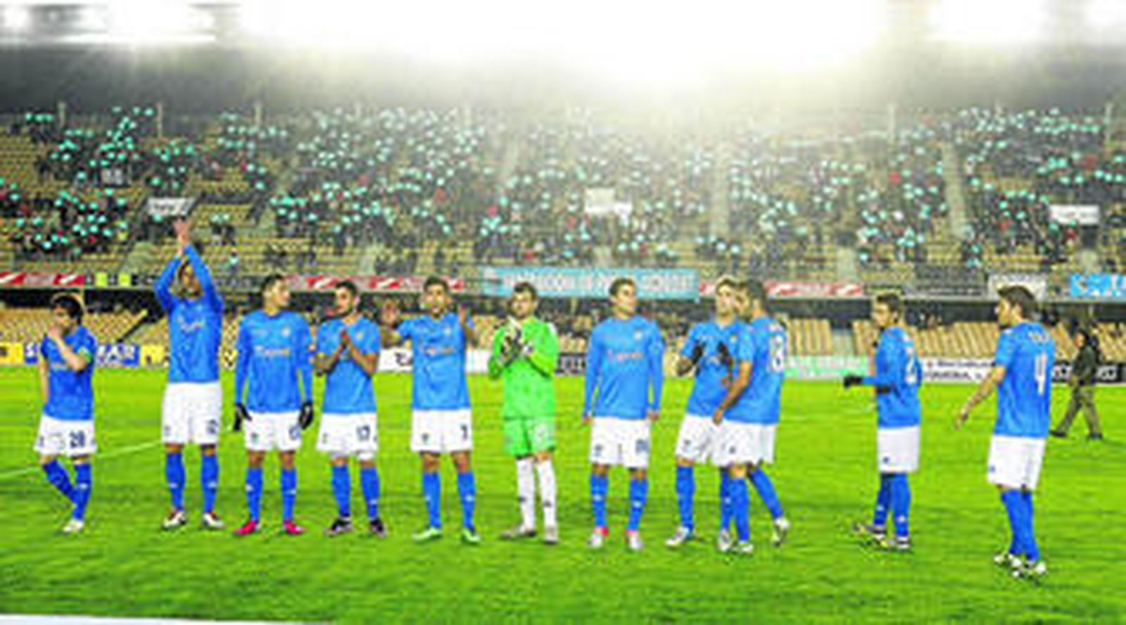 La primera alineación de Carlos Ríos, con el mosaico desplegado en la tribuna de Preferencia a la salida de los futbolistas.