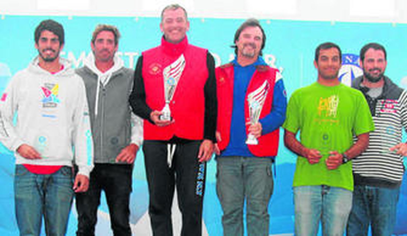 Podio de la Regata Ibérica de Tavira, con Pepe Ruiz y José Sánchez mostrando los trofeos conseguidos.