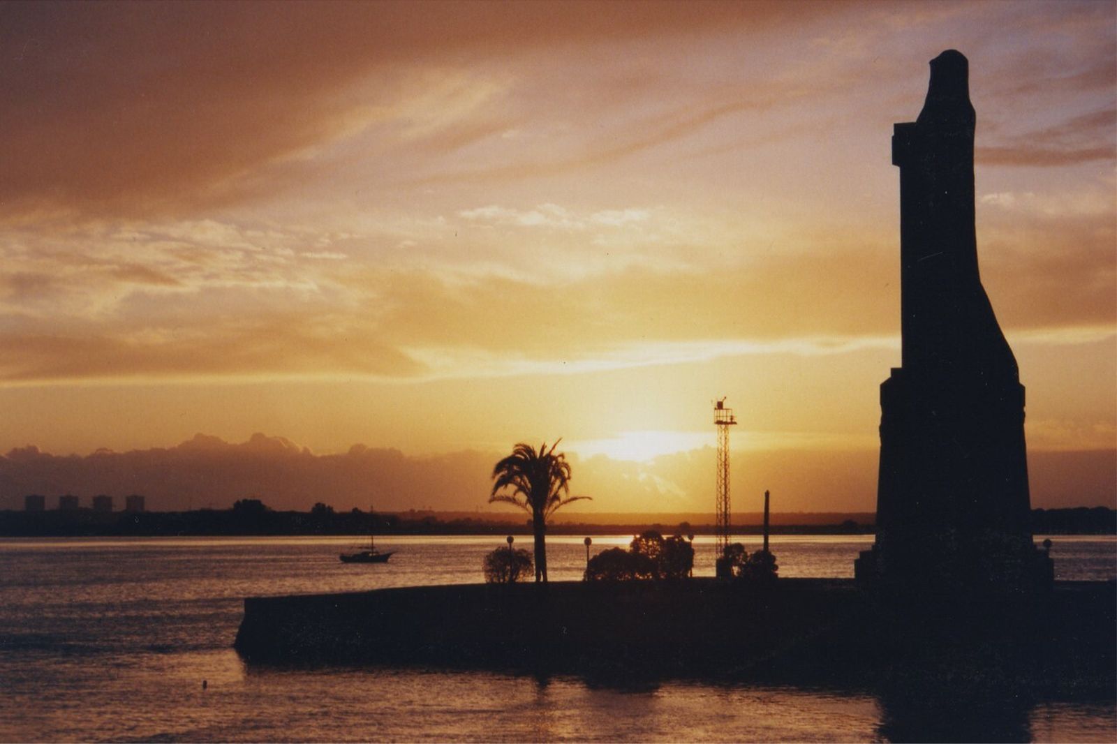 Puesta de sol ante el Monumento a Colón, que marca el camino hacia América.