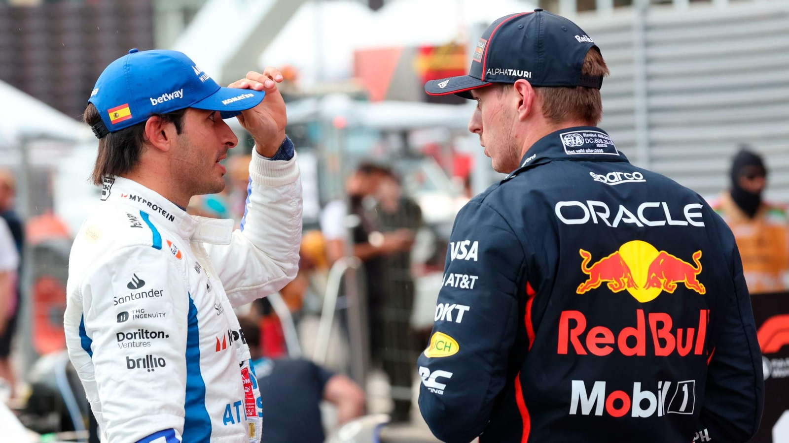 Max Verstappen y Carlos Sainz conversando.
