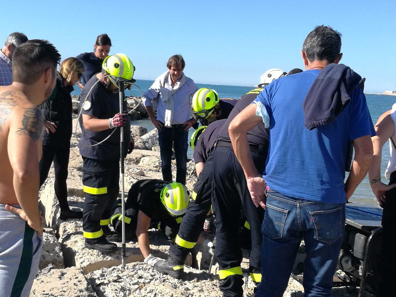 Los bomberos durante la actuación para rescatar al perro en Santa María del Mar en Cádiz.
