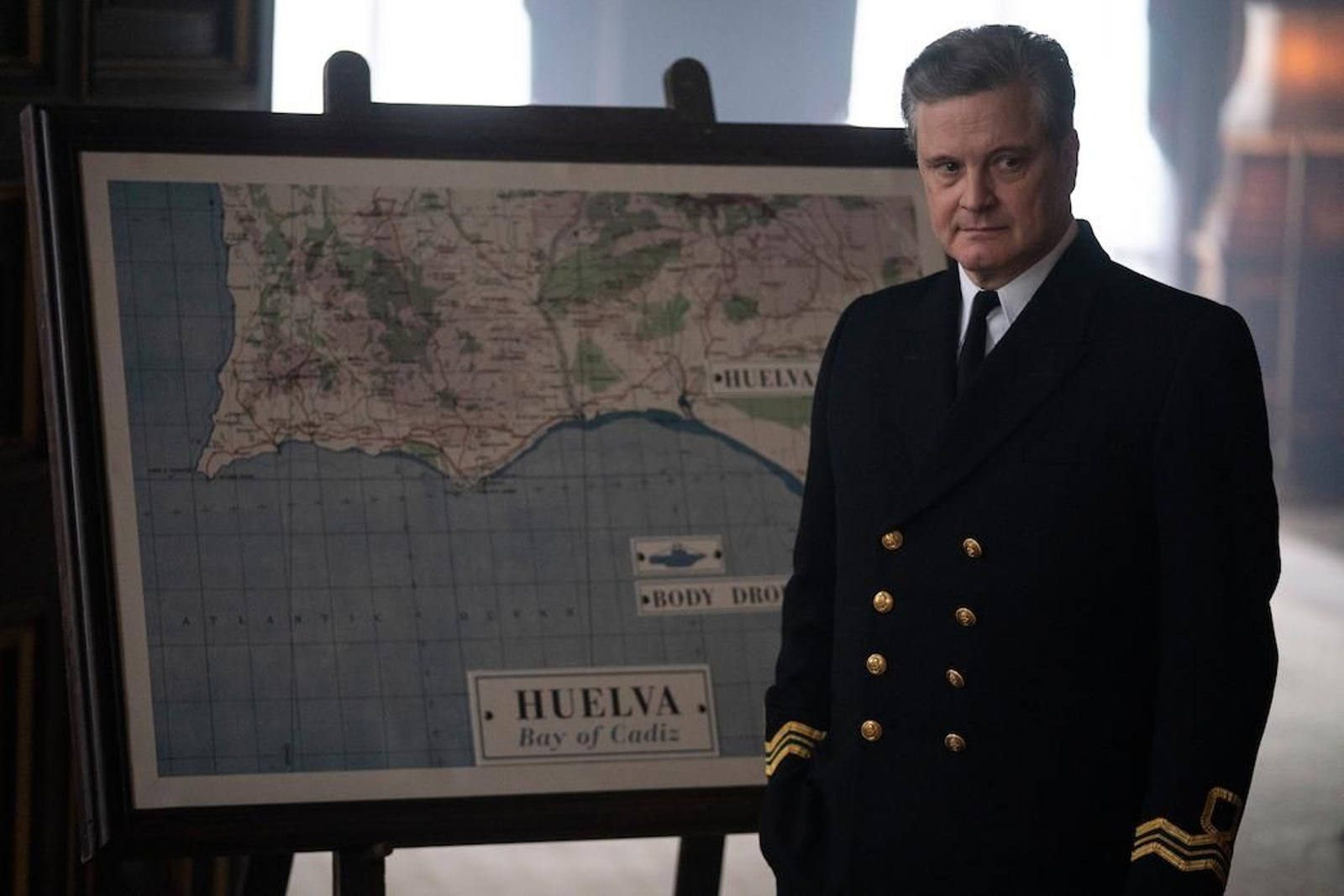 El actor Colin Firth, en la película, ante un mapa de la costa de Huelva.