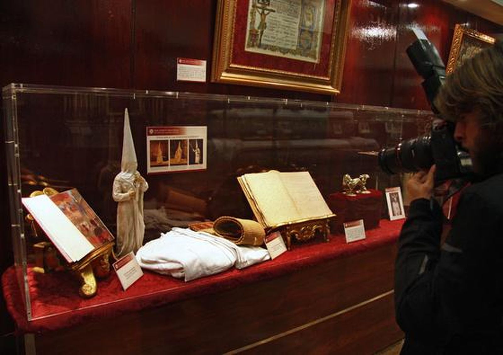 Los visitantes aprecian los objetos de la exposición "Tan lejos y tan cerca", de la Hermandad de la Amargura.

Foto: Belen Vargas