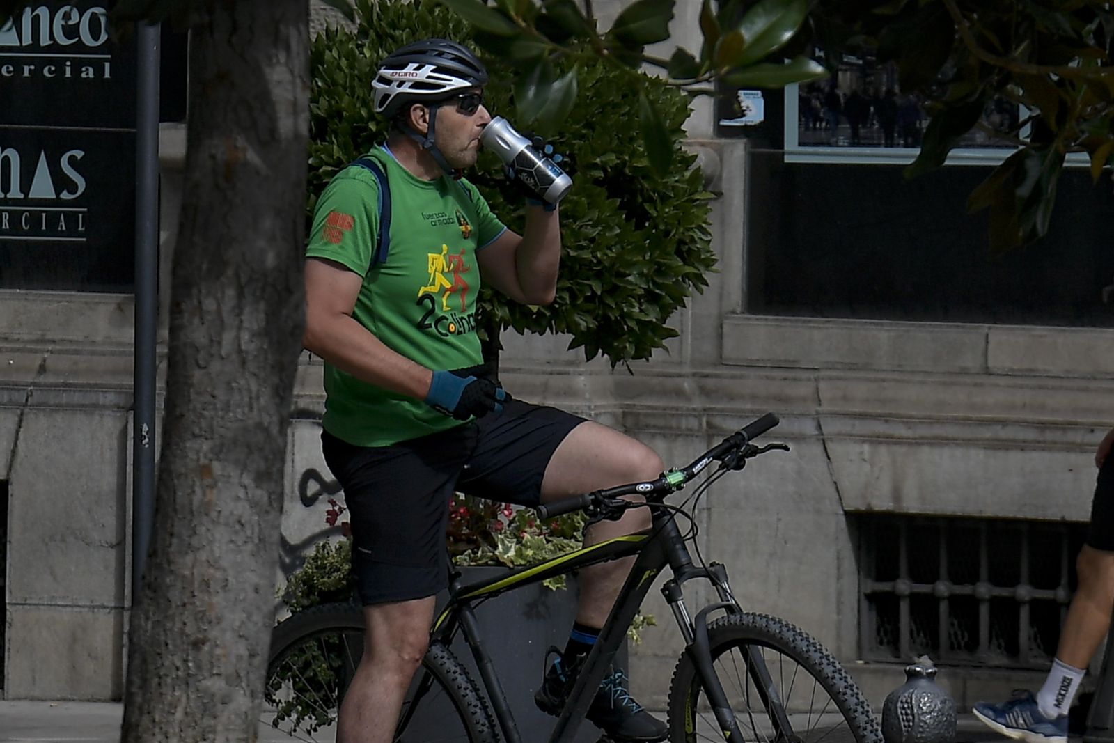 Un ciclista se refresca en una calle del centro de Granada