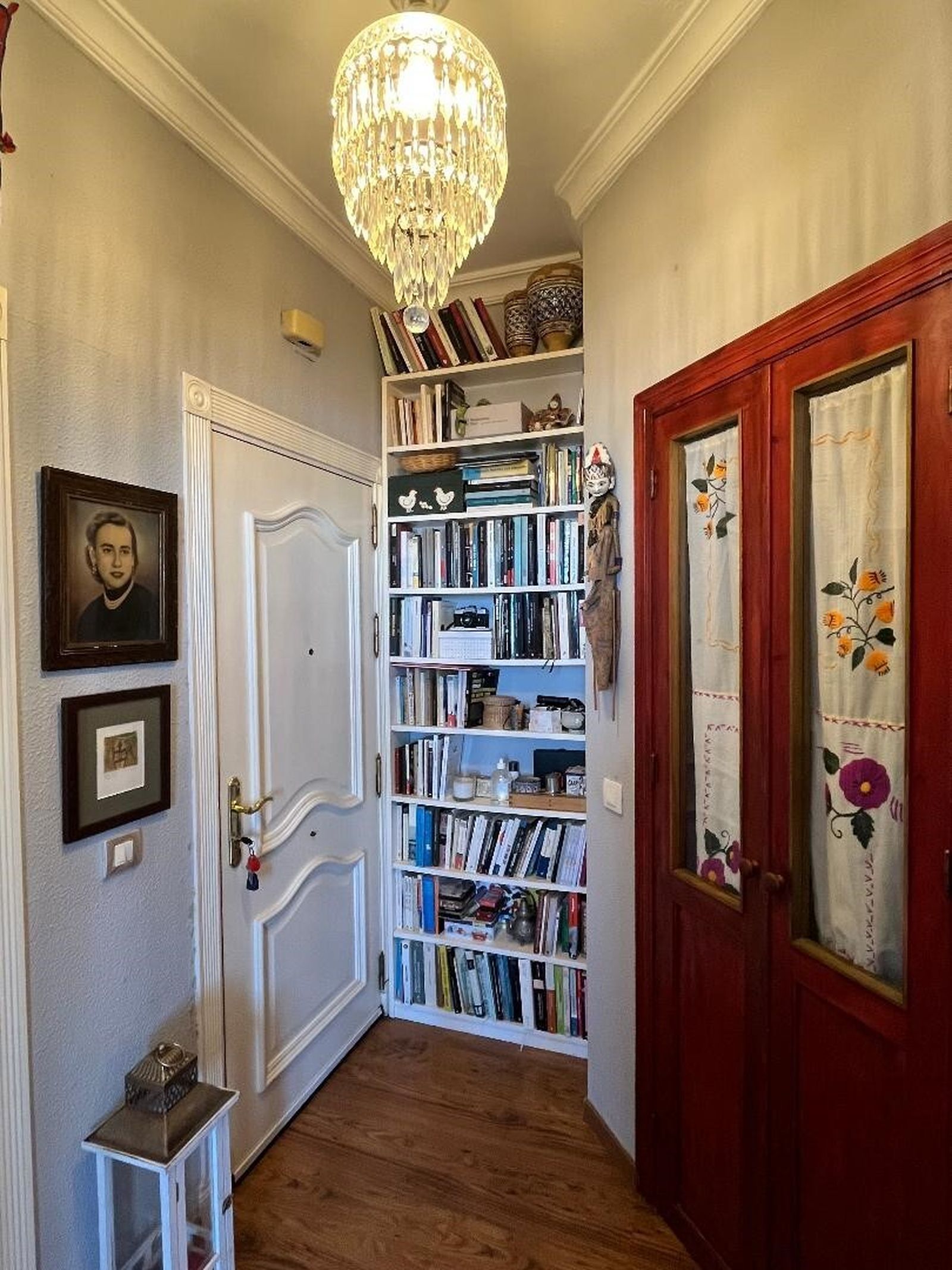 Estantería con una biblioteca en la entrada de la casa.