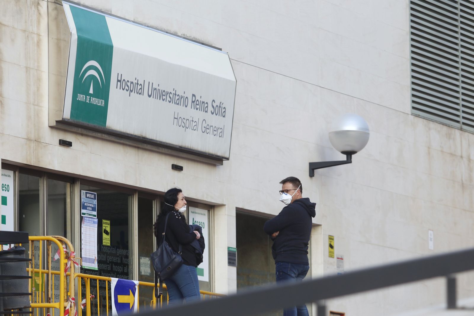 Dos personas esperan en la puerta del Hospital General.