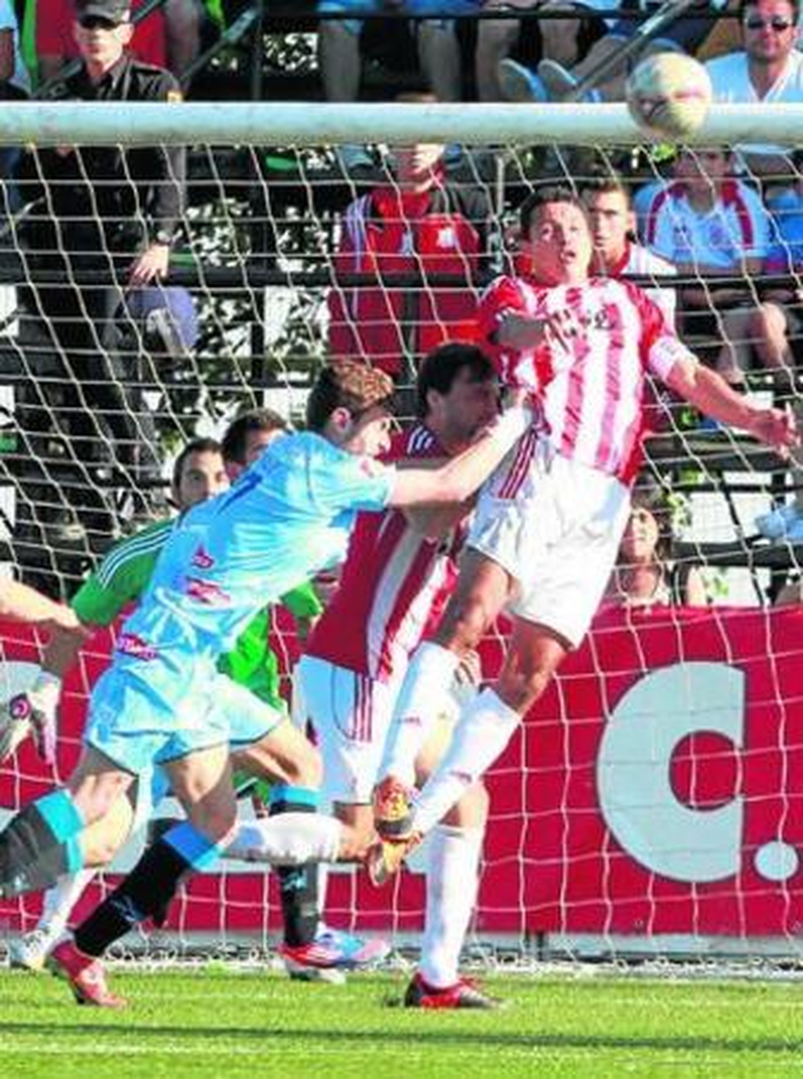 Amarilla despeja de cabeza por delante de sus compañeros San Julián y Paco, y pese al empujón de José Cruz.