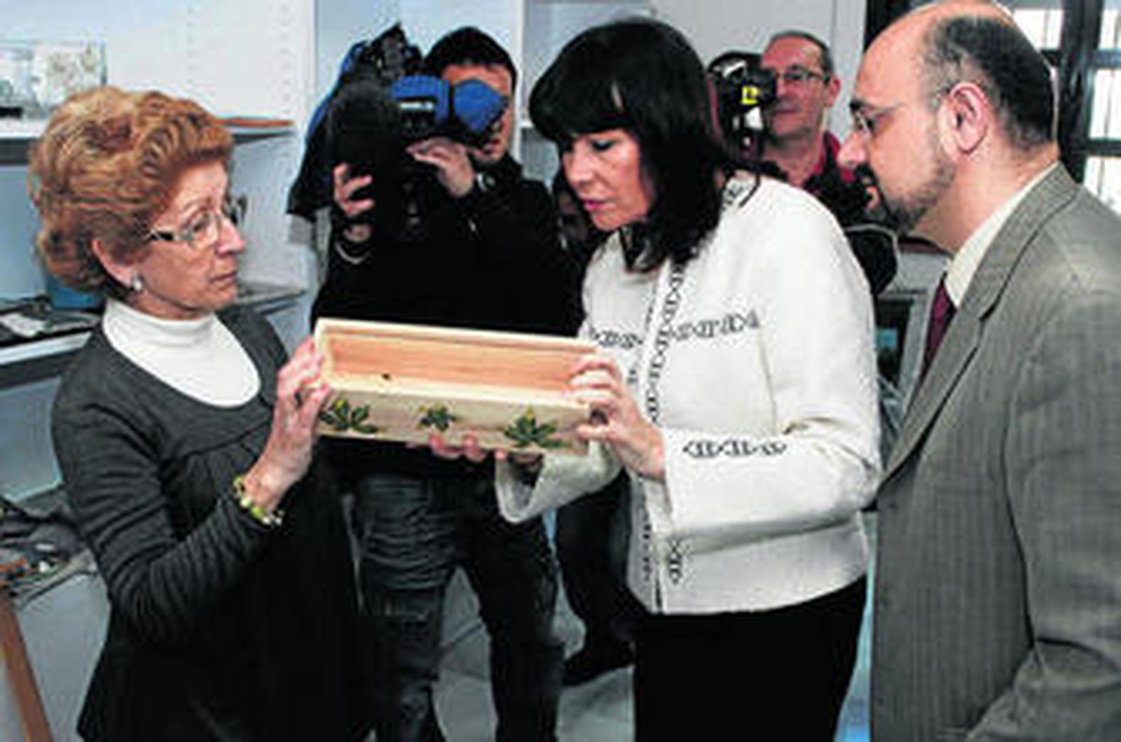 Una usuaria del centro muestra uno de los trabajos que se hacen en presencia de las autoridades.