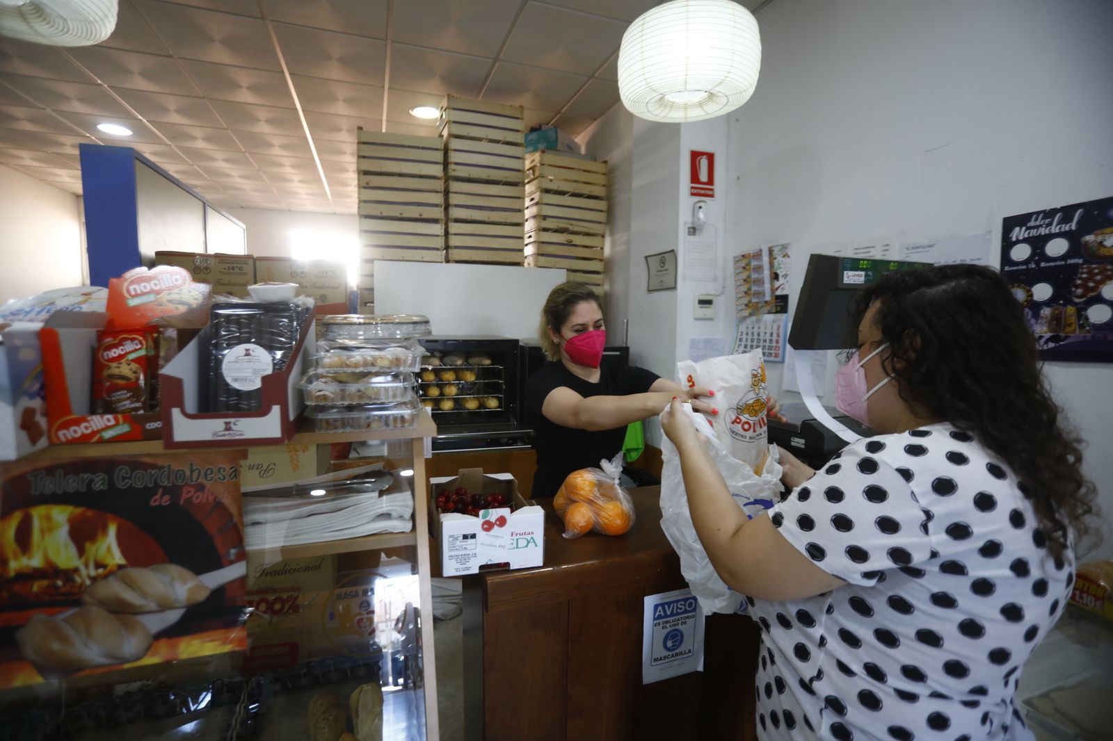 Una dependienta atienda a una mujer en su tienda.
