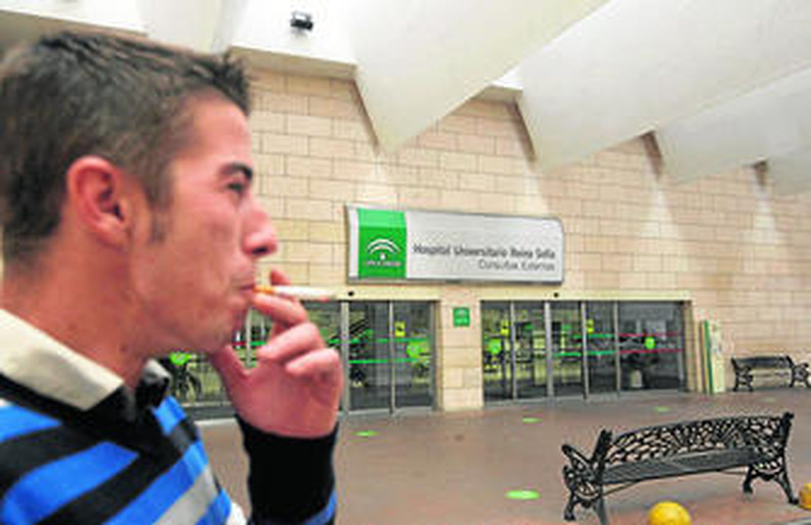 Un hombre fuma en el vestíbulo del Hospital Reina Sofía, donde el consumo de tabaco está prohibido.