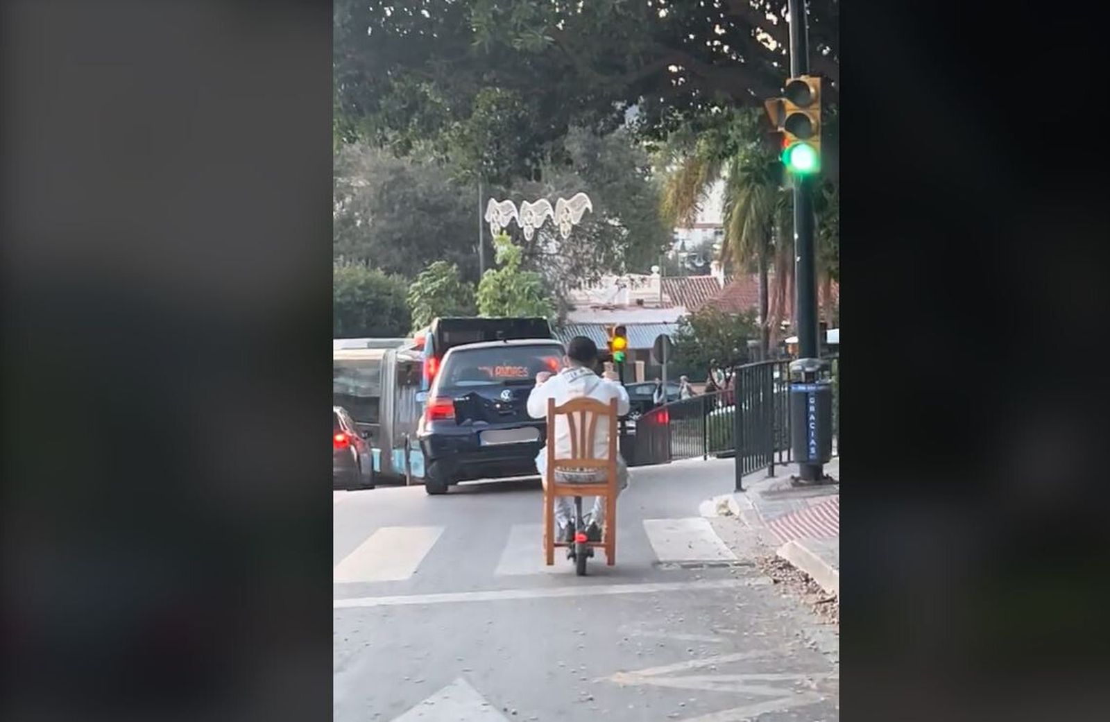 La insólita imagen de un conductor de patinete eléctrico sentado en una silla en Málaga.