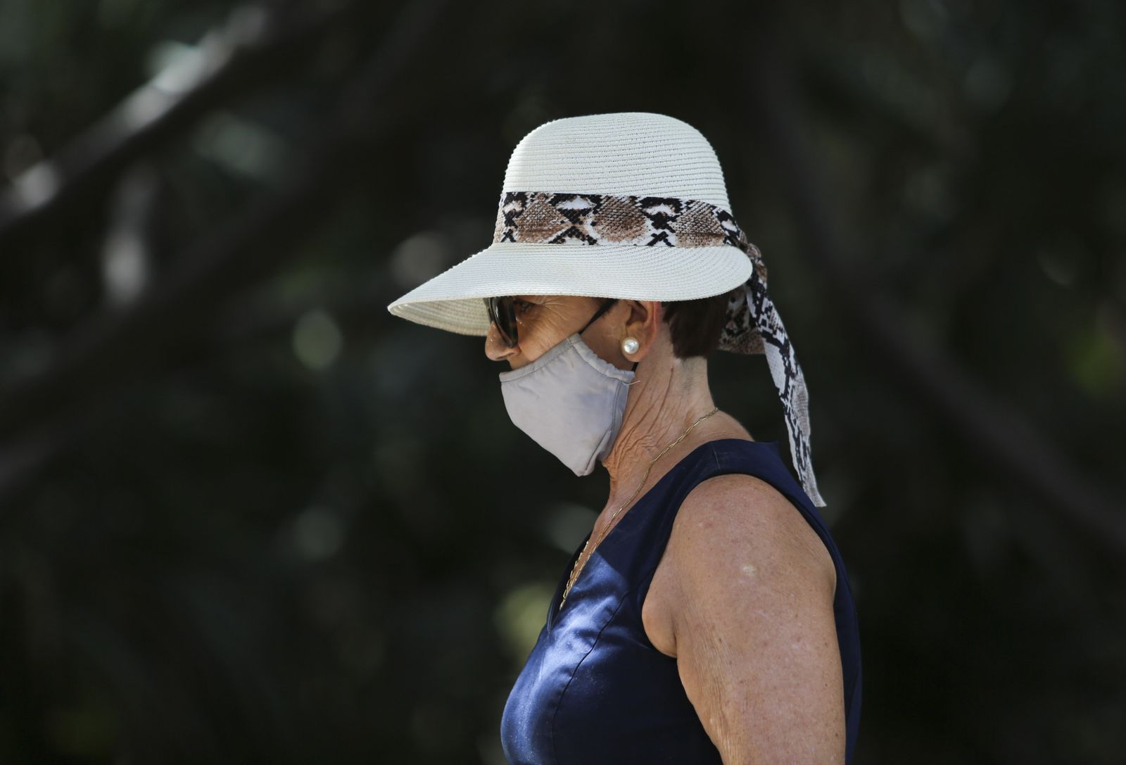 Una mujer se protege del sol con un sombrero.