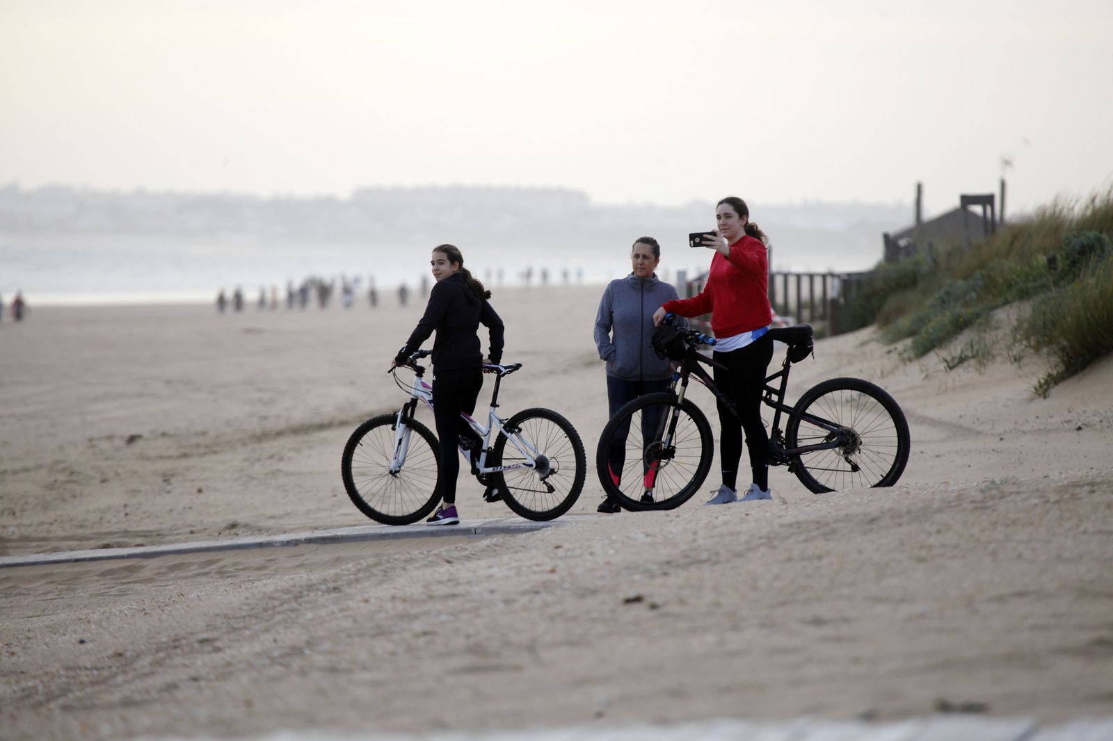 Un grupo de personas realiza una fotografía de la playa durante el desconfinamiento.