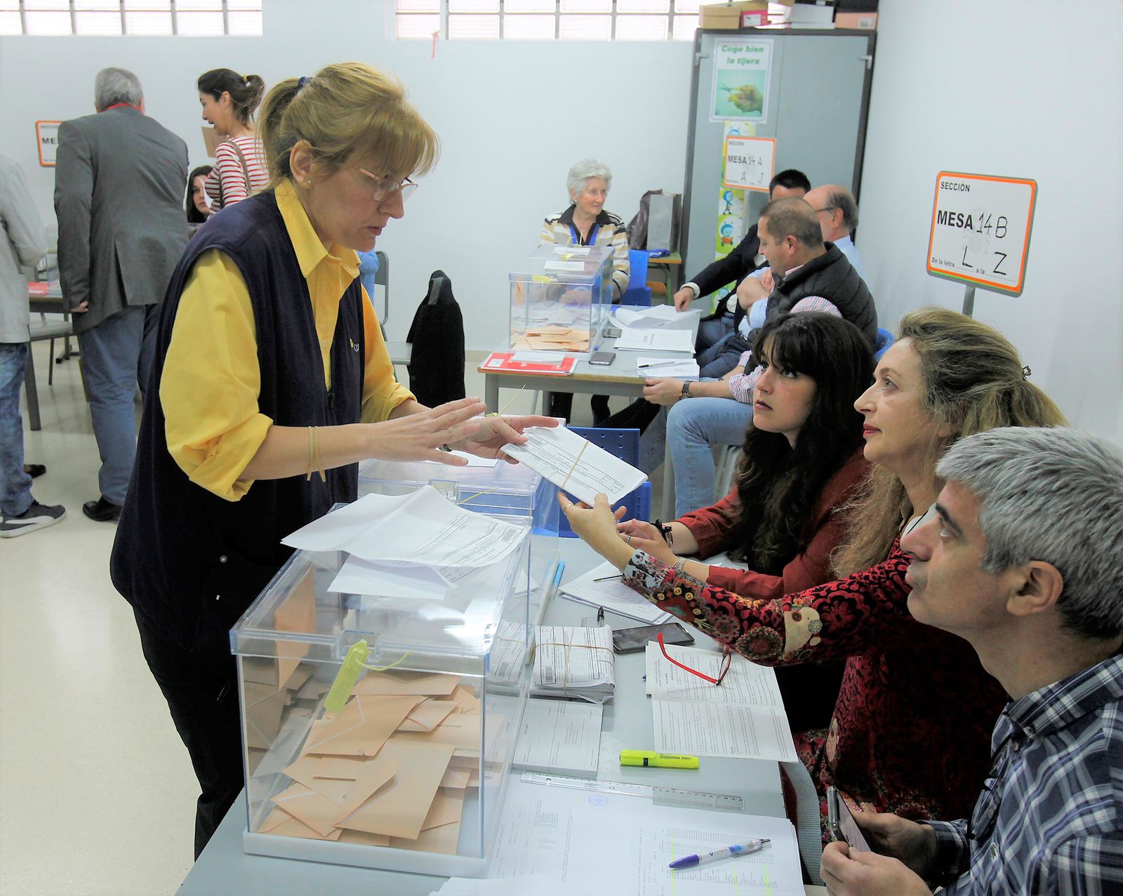 Una empleada de Correos entrega votos en una mesa electoral.