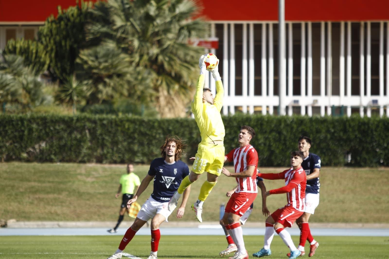 El guardameta del conjunto sevillano detiene el balón durante una acción del encuentro de los rojiblancos.