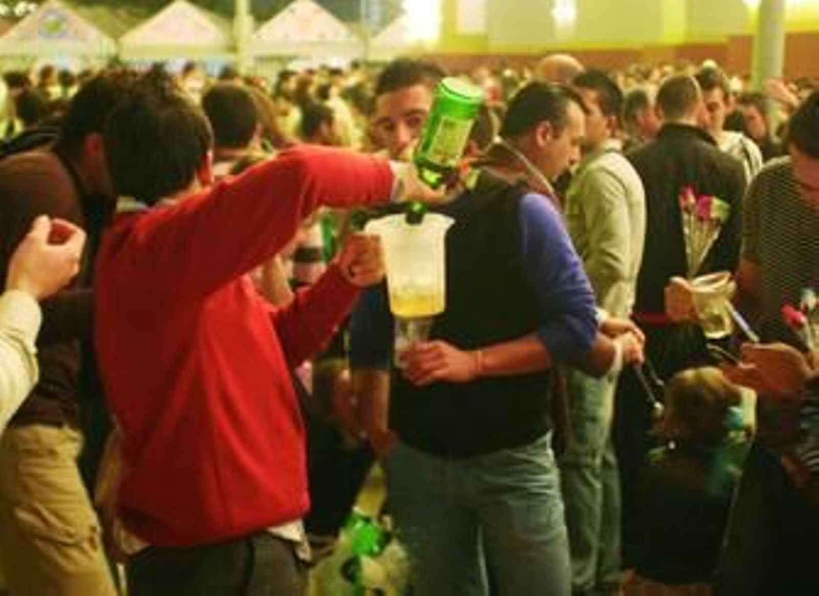 Un grupo de jóvenes celebra una 'botellona' a los pies de la portada de la Feria.