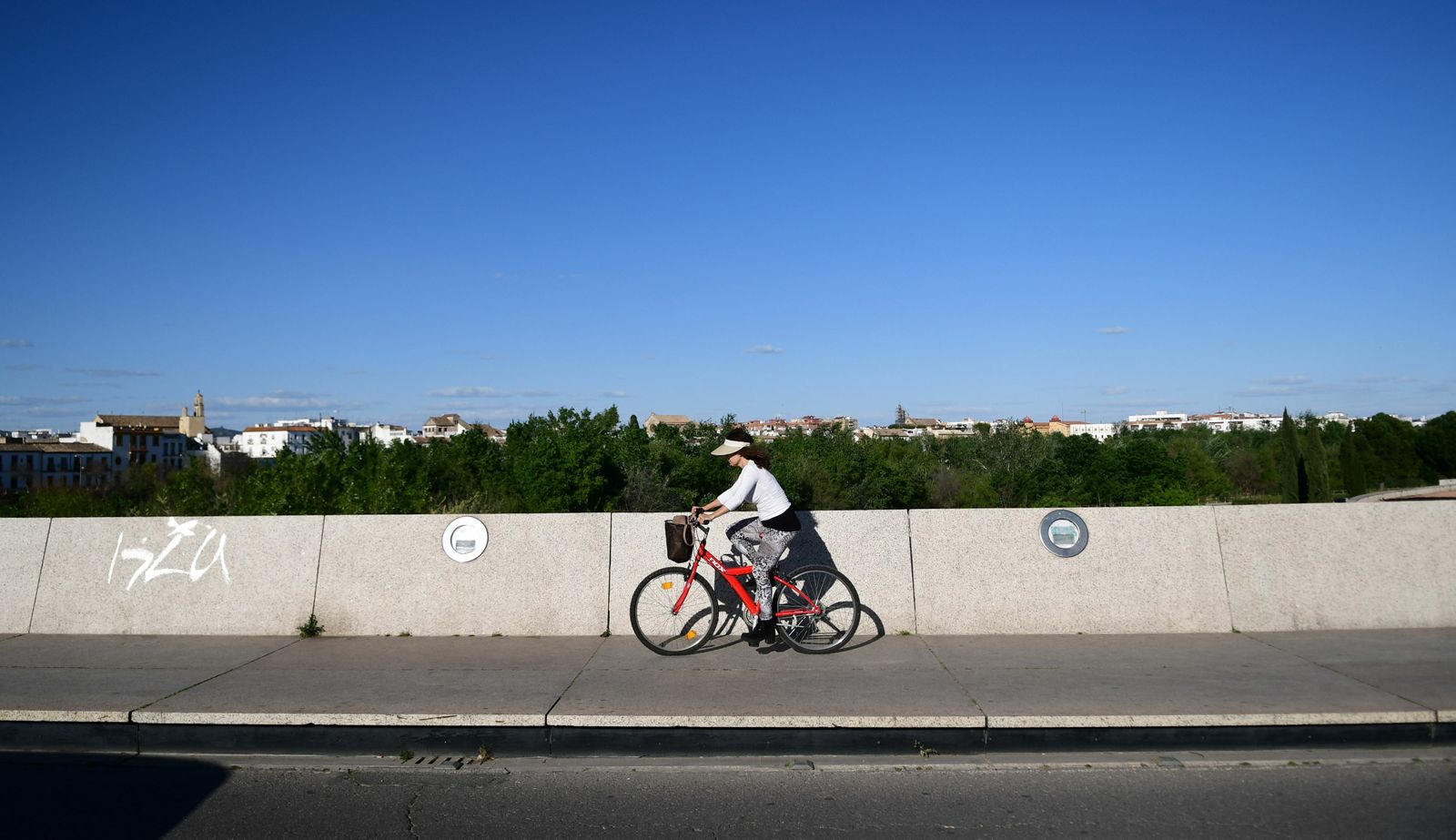 Una mujer pasea en bicicleta por la Ribera.