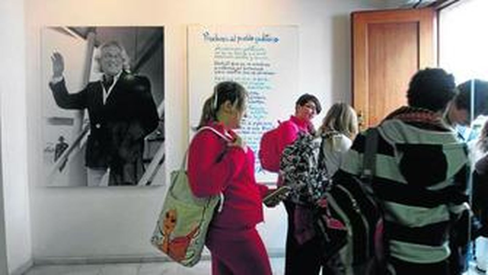 Un niño lee un texto de Alberti ante una gran foto del poeta.