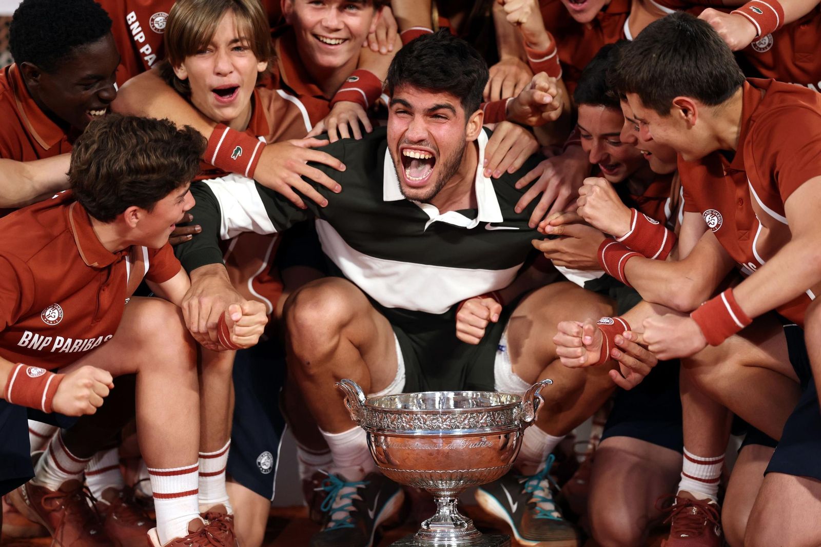 Carlos Alcaraz, muy feliz con el trofeo junto a los recogepelotas.