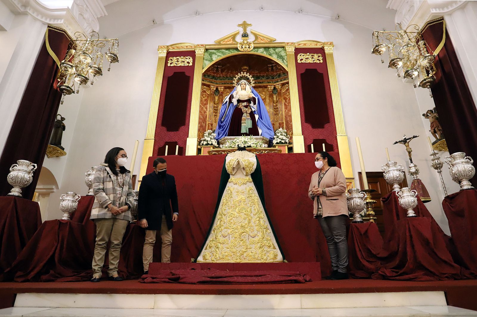 Los bordadores del Taller de Charo Bernardino presentaron la nueva saya a los pies de la Virgen de la Esperanza.