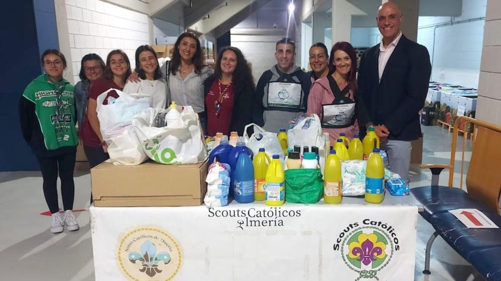 Alfredo Cortés, presidente de Unicaja Costa de Almería, junto con los voluntarios del Movimiento Scout Católico.