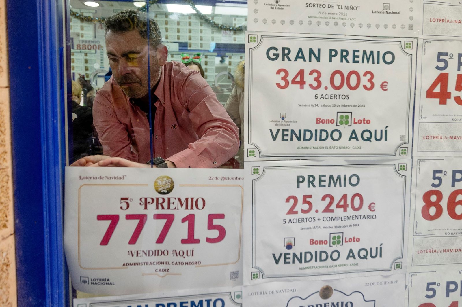 Colocación del cartel anunciador de un quinto premio en la Administración de Loterías 'El Gato Negro' de Cádiz.