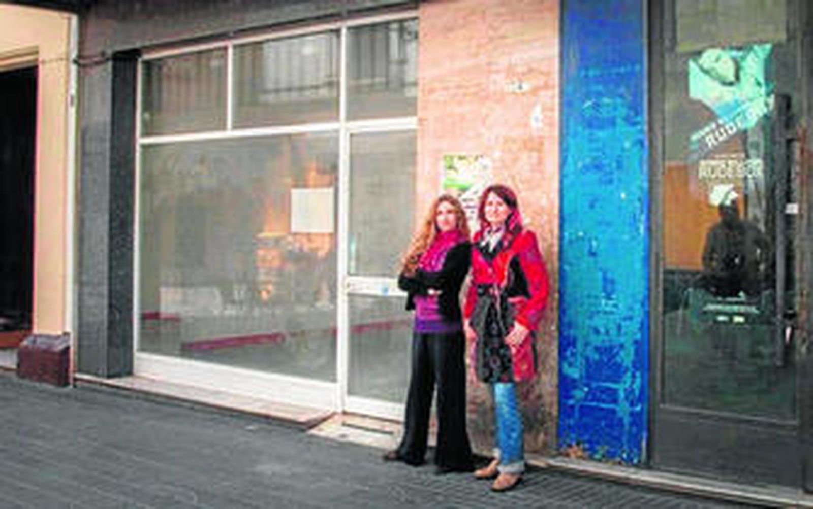 Las artistas Paz de la Calzada y Mona Caron, delante de uno de los numerosos escaparates vacíos del centro de la ciudad.