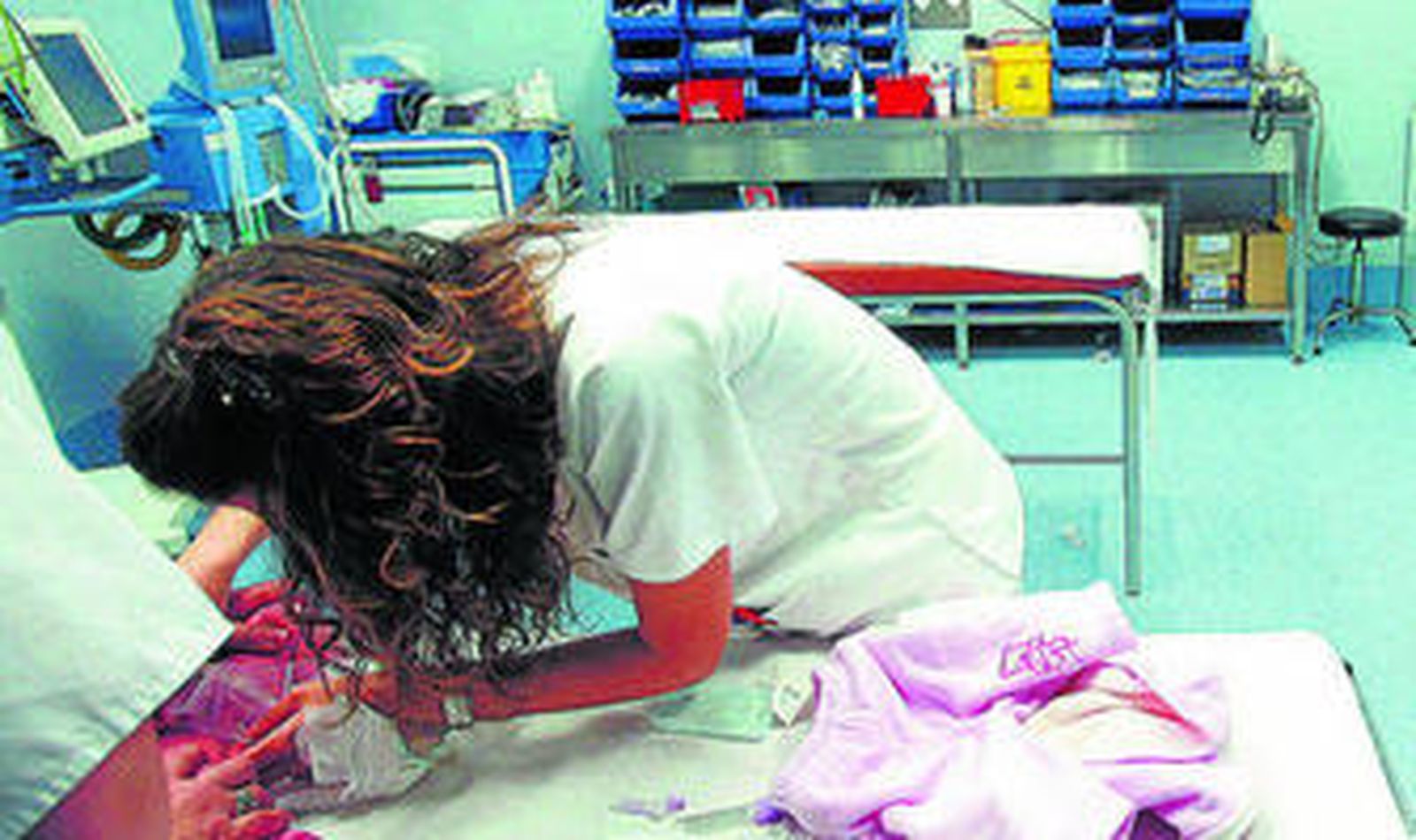 Una pediatra chequea a un bebé en una consulta de especialidades hospitalaria.