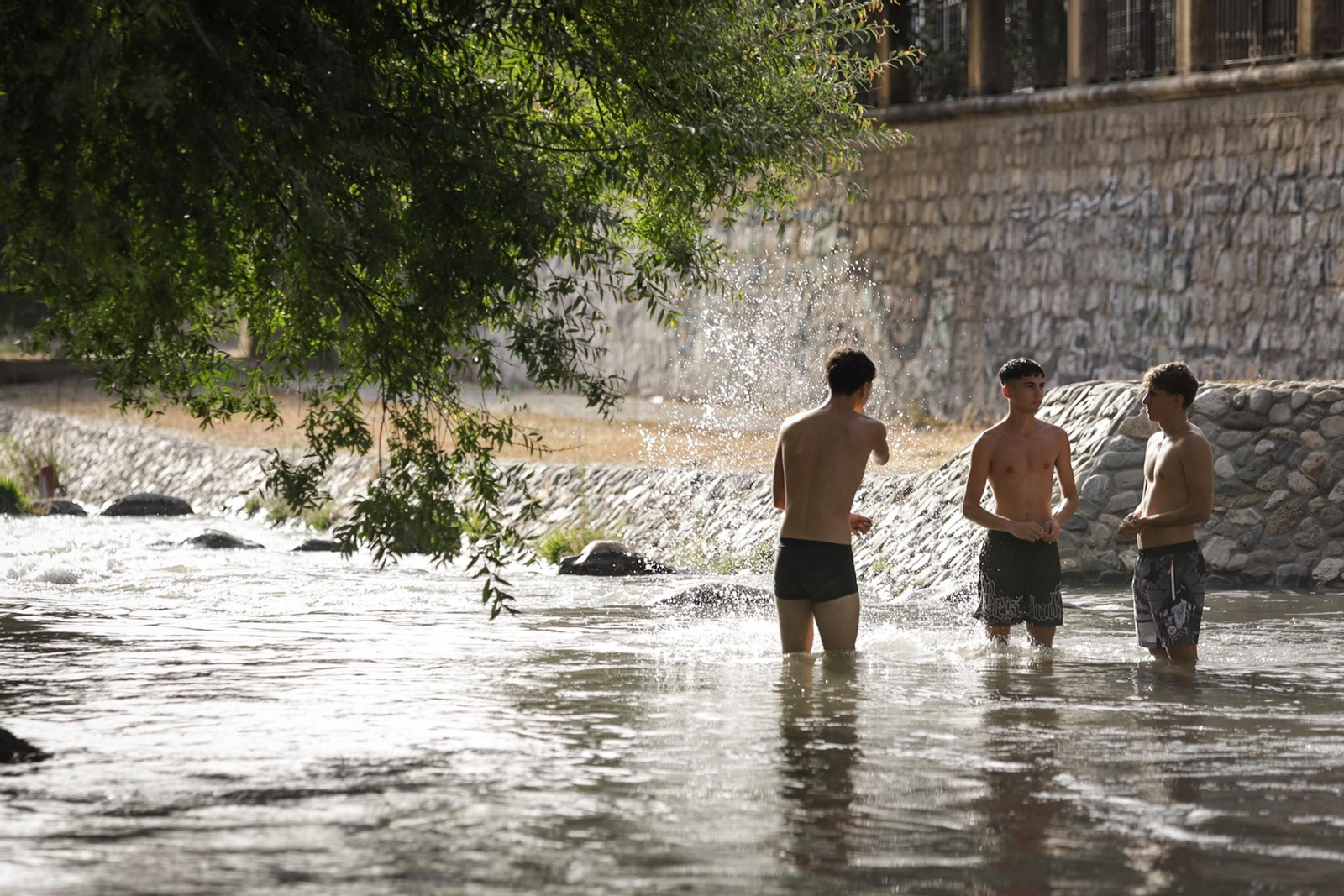 Unos jóvenes se bañan en el Río Genil