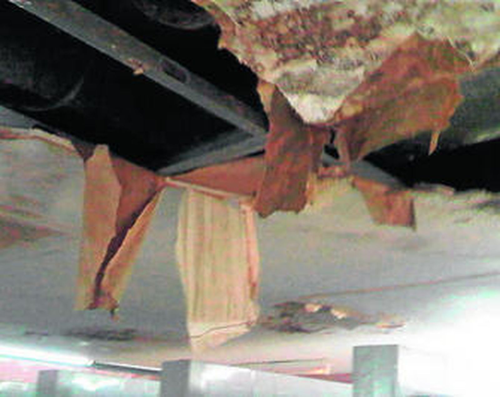 1. El techo de los vestuarios de la Unidad de Intervención Policial, completamente desprendido por la humedad acumulada durante años. 2. Una de las duchas del cuartel del Cortijo de Cuarto, inutilizada y con un lavabo roto dentro. 3. Un termo del agua caliente, caído de la pared y en el suelo de los vestuarios. 4. El agua cae del techo y se acumula en un charco en mitad de los vestuarios, que apenas son utilizados por los funcionarios que tienen su sede en este edificio.