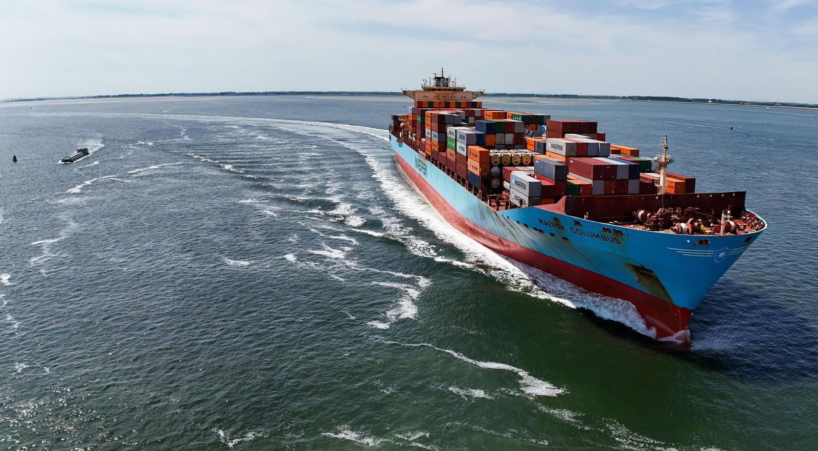Un enorme barco cargado con cientos de contenedores se aproxima al puerto de Amberes.
