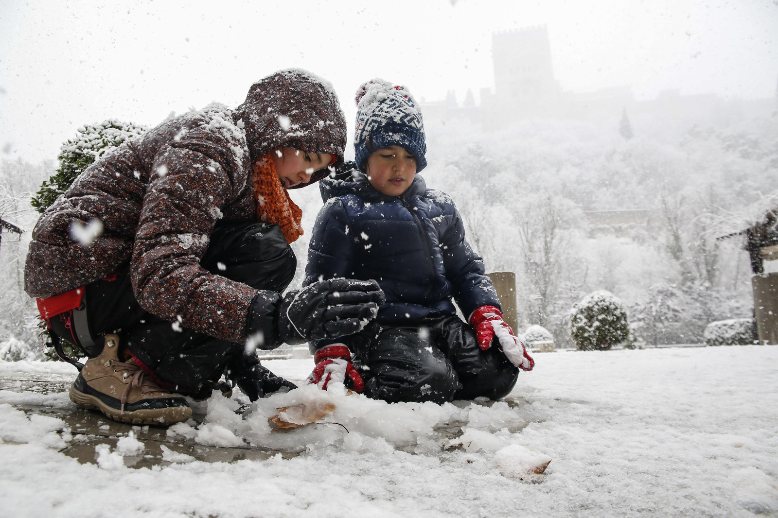 Dos niños juegan con la nieve en Granada.