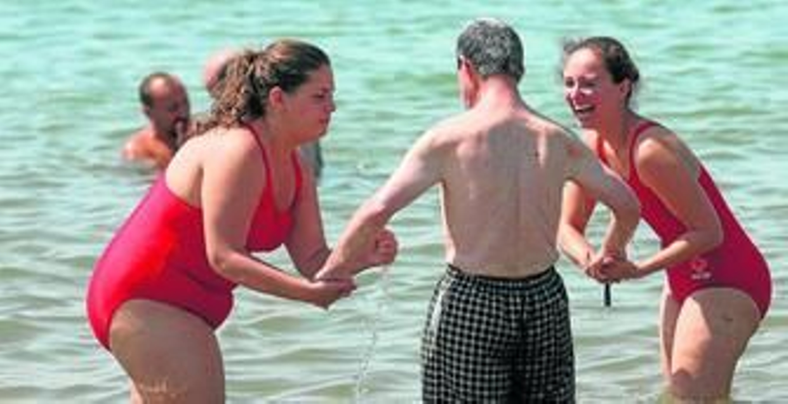 Los voluntarios de Cruz Roja ayer con algunos de los usuarios del programa Un baño sin barreras.