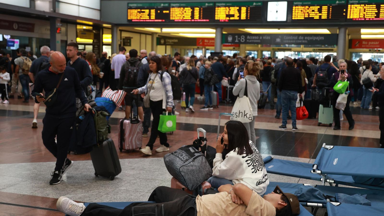 Viajeros aún en las camillas colocadas por Cruz Roja en la estación de tren María Zambrano.