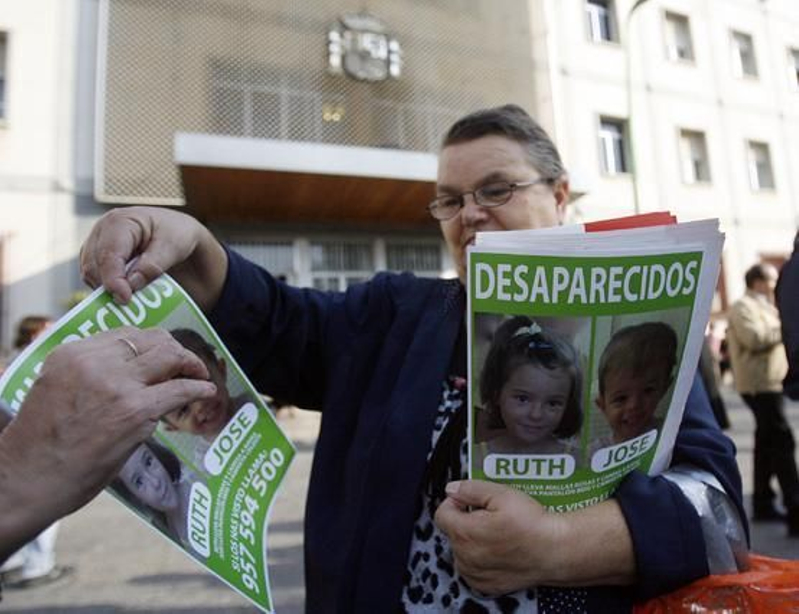 Reparto de carteles con las fotografias de los niños.