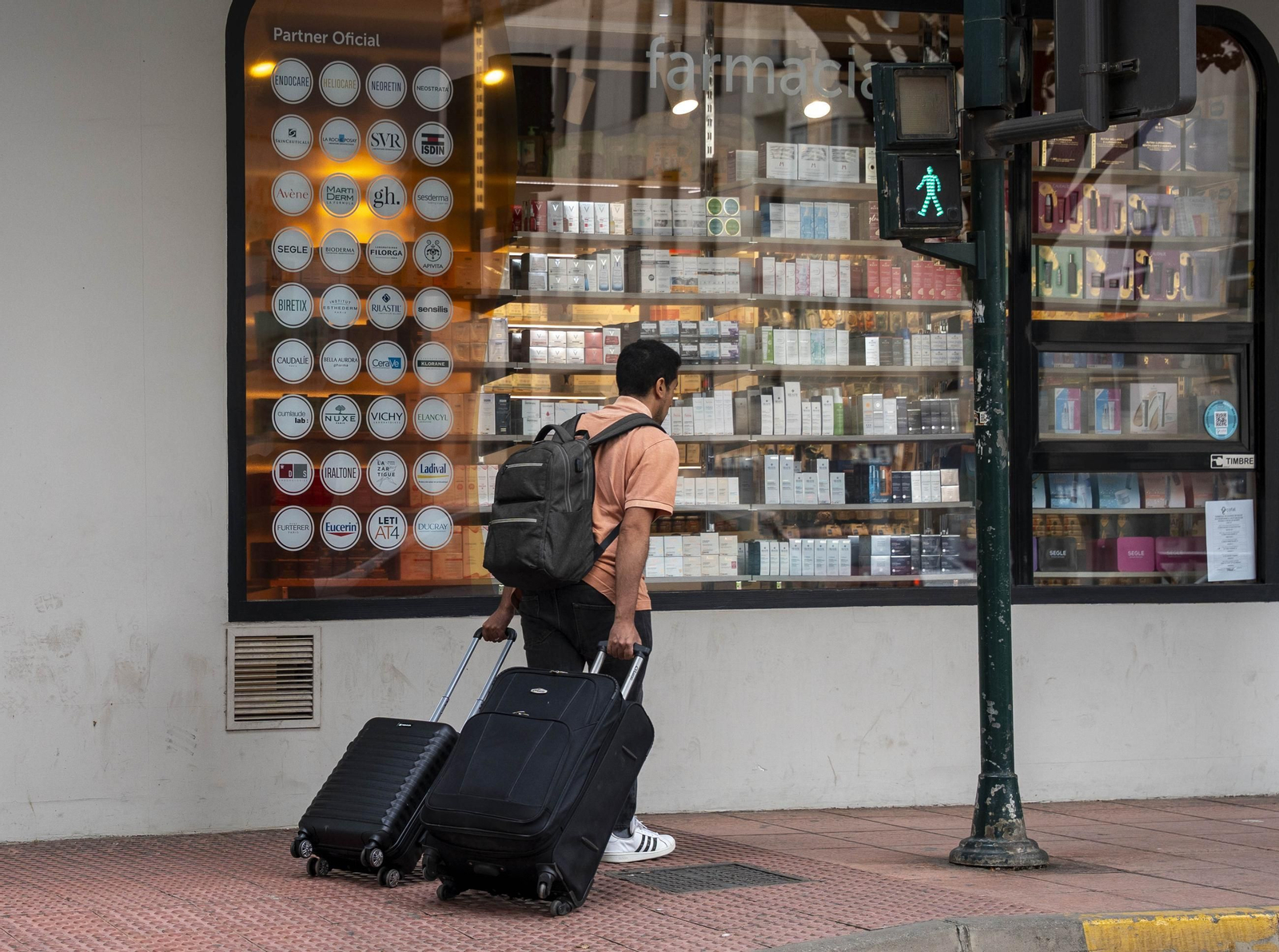 Un joven anda con sus maletas por las calles de Almería capital.