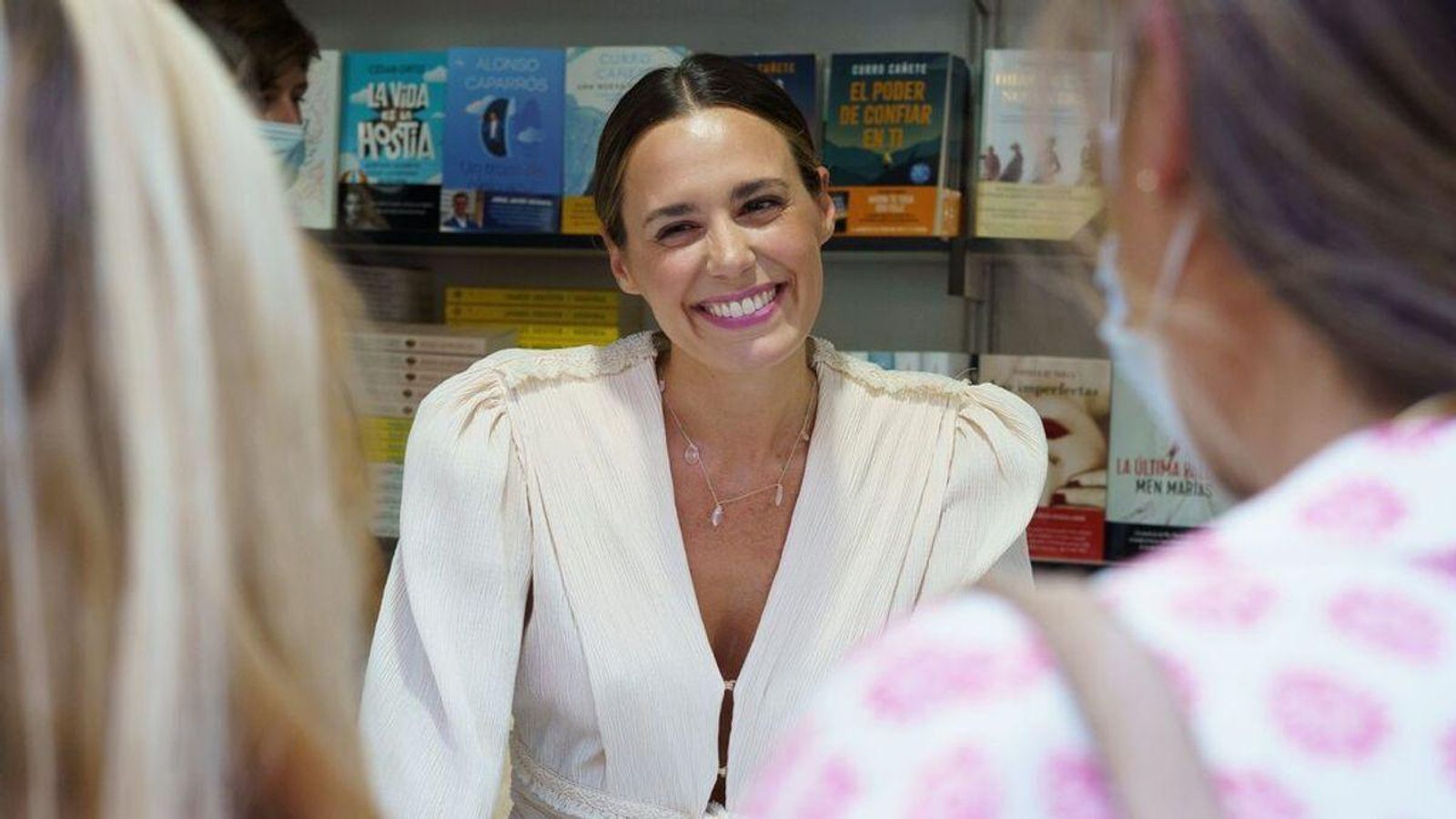 Primer plano de Claudia en una firma de libros.