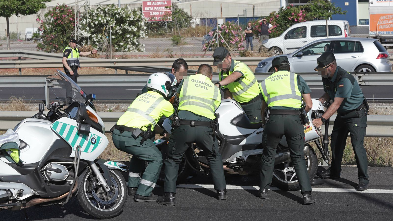 Compañeros del guardia civil, Fermín Cabezas, levantan su moto tras el accidente que le costó la vida.