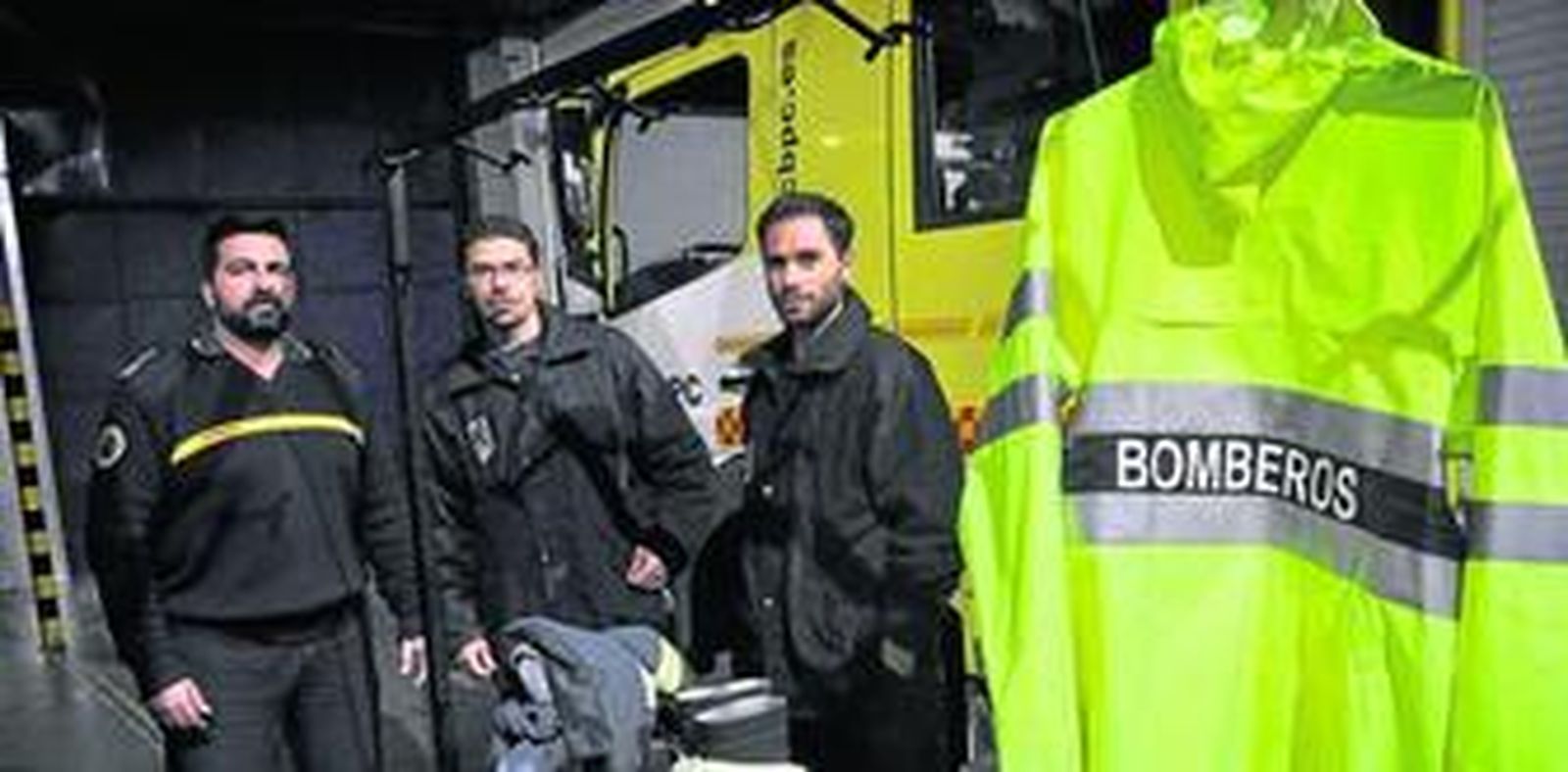Tres de los bomberos que han trabajado esta Nochebuena ante el camión.