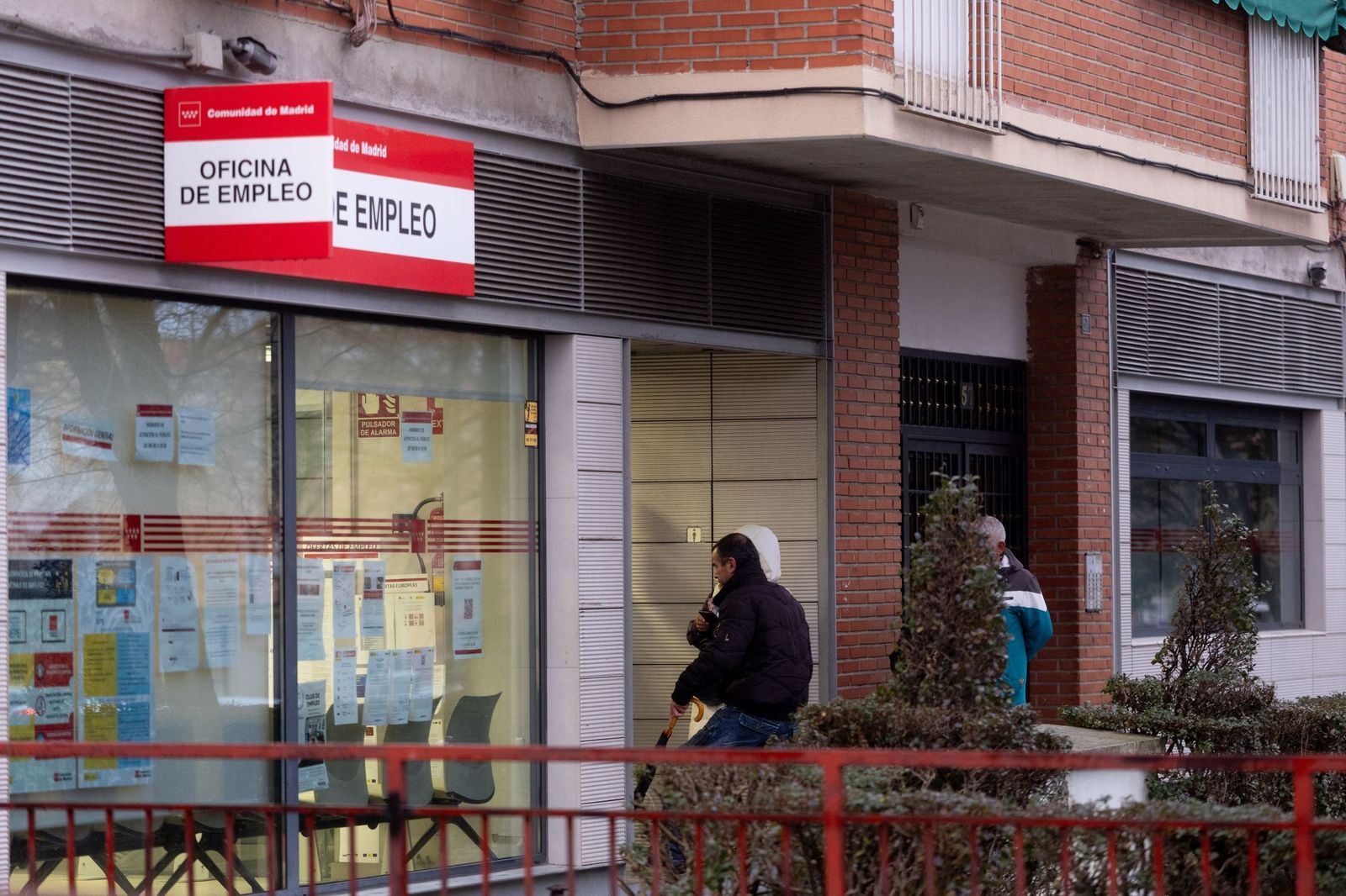 Varias personas hacen cola para entrar en una Oficina  de  Empleo.