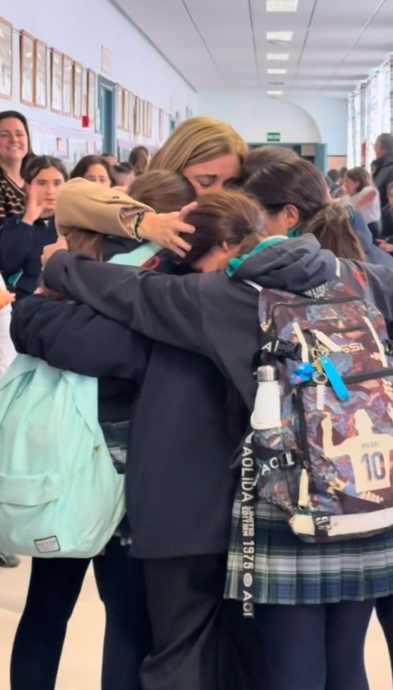 Alumnos se abrazan a la maestra.