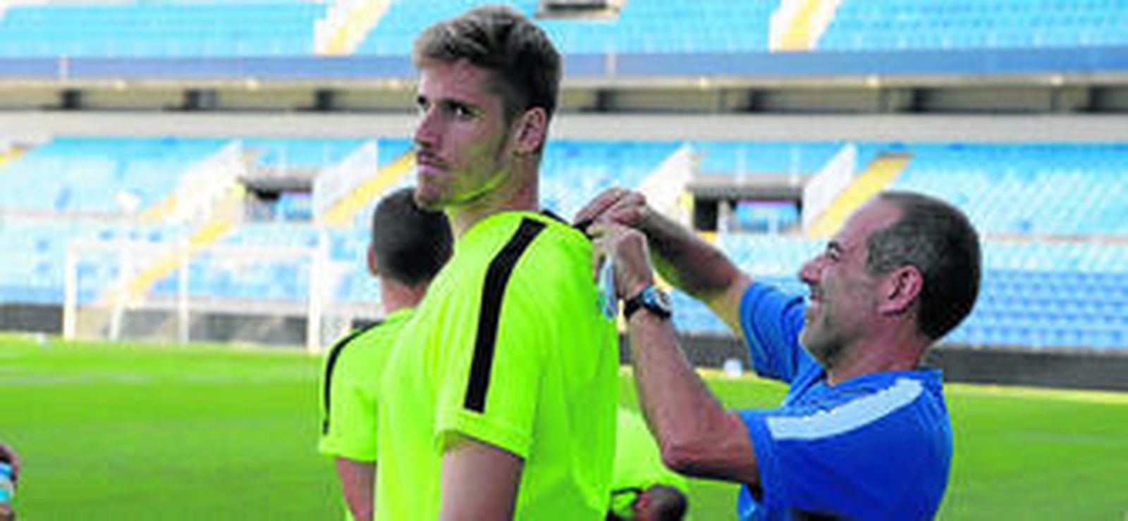 El preparador físico Enrique Ruiz ayuda a Albentosa a enfundarse bien el pulsómetro.