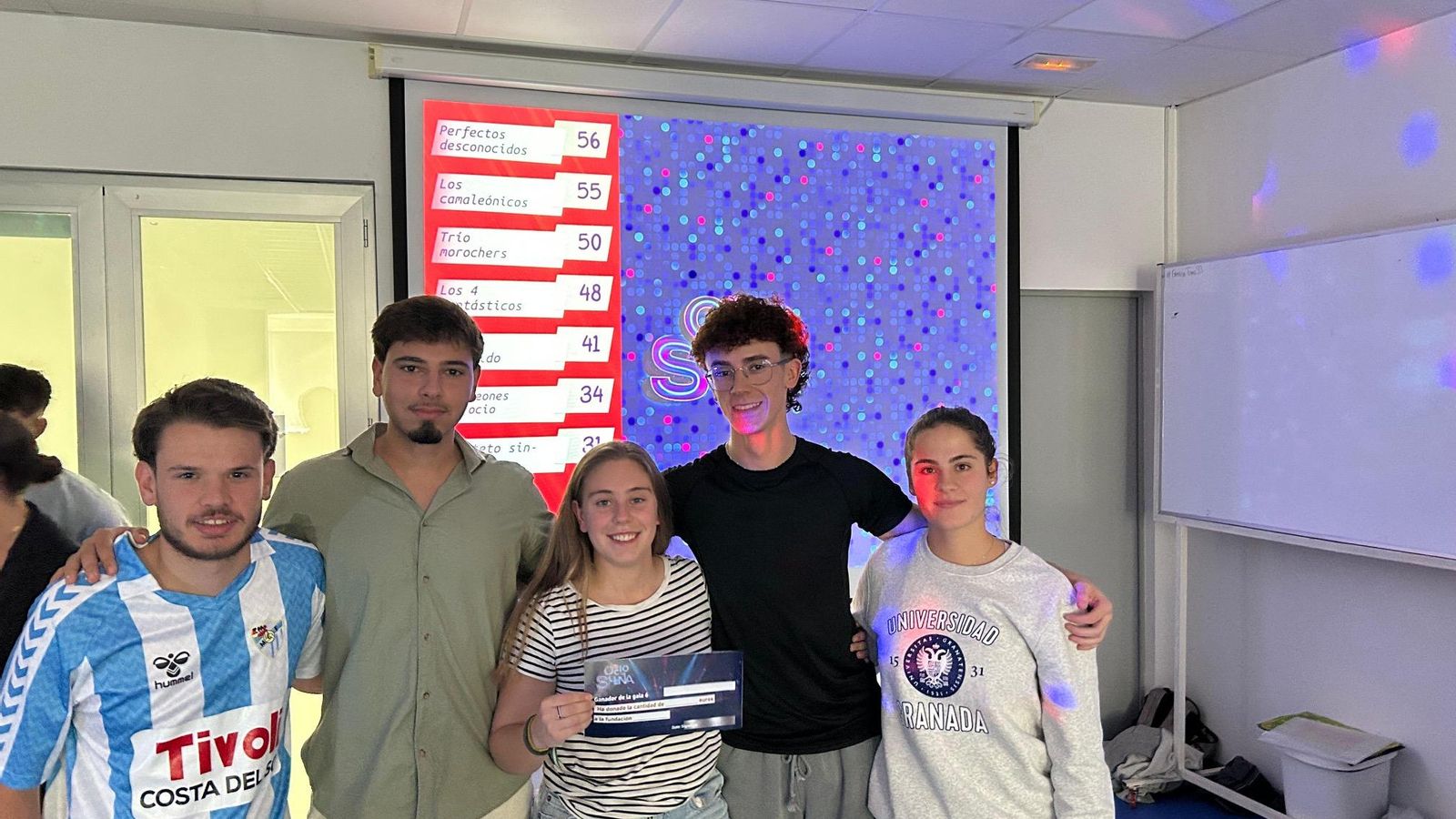 Grupo de alumnos posando con un 'cheque'