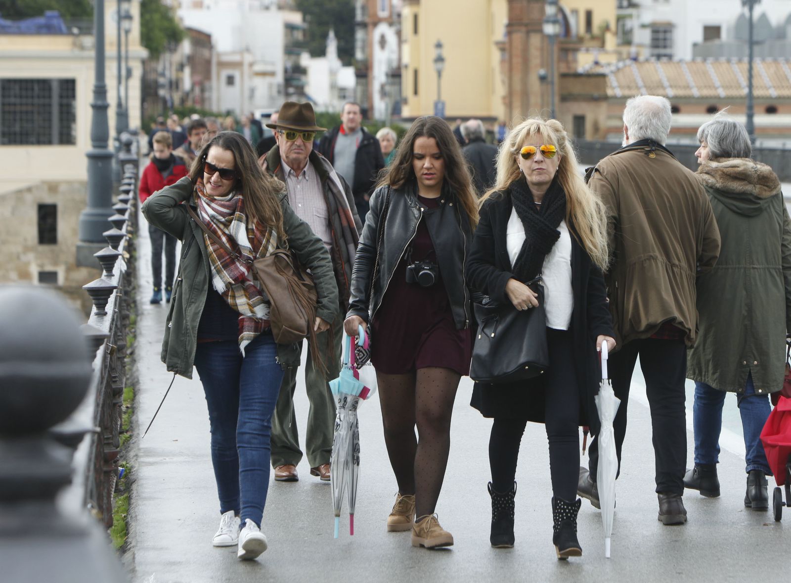 Varias personas caminan abrigadas por Sevilla.
