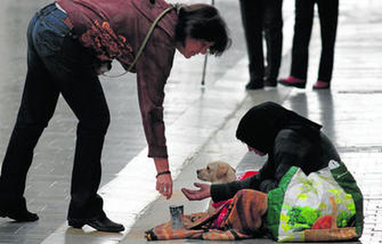 Una mujer pide limosna en una de las calles del centro de Málaga.