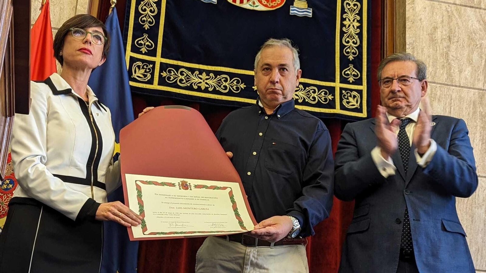 Familiar de Luis Montero García junto al diploma de reparación.