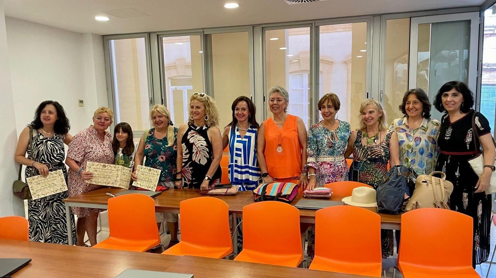 Participantes muestran sus diplomas acreditativos