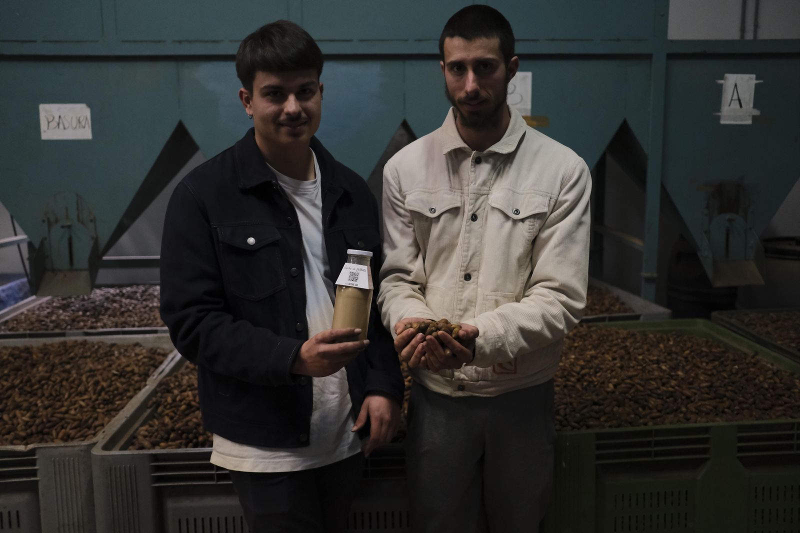 Pedro y Javier con una muestra de su leche de bellota en el secadero de Parauta.