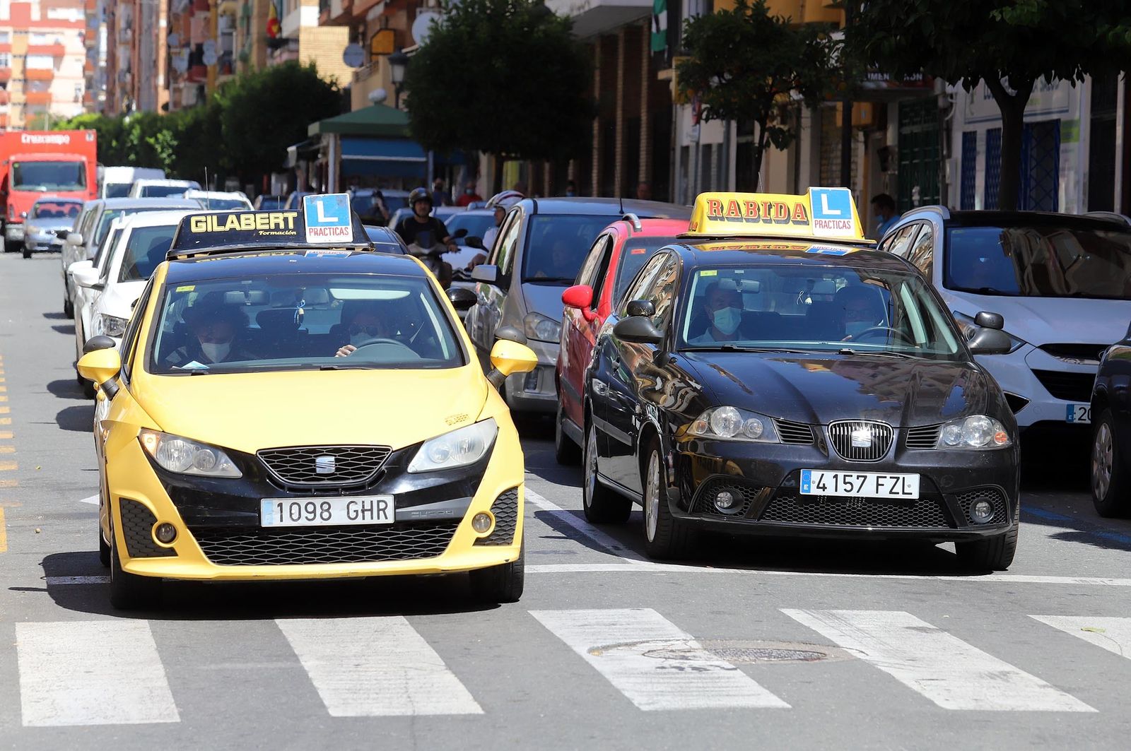 Dos coches de autoescuelas circulan por la capital onubense.
