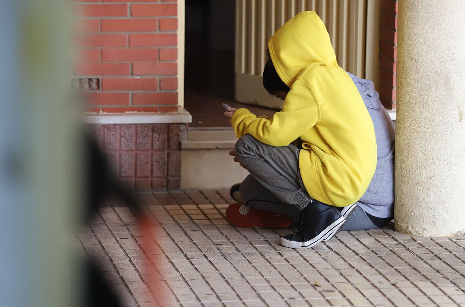 Un estudiante en la entrada de un instituto.